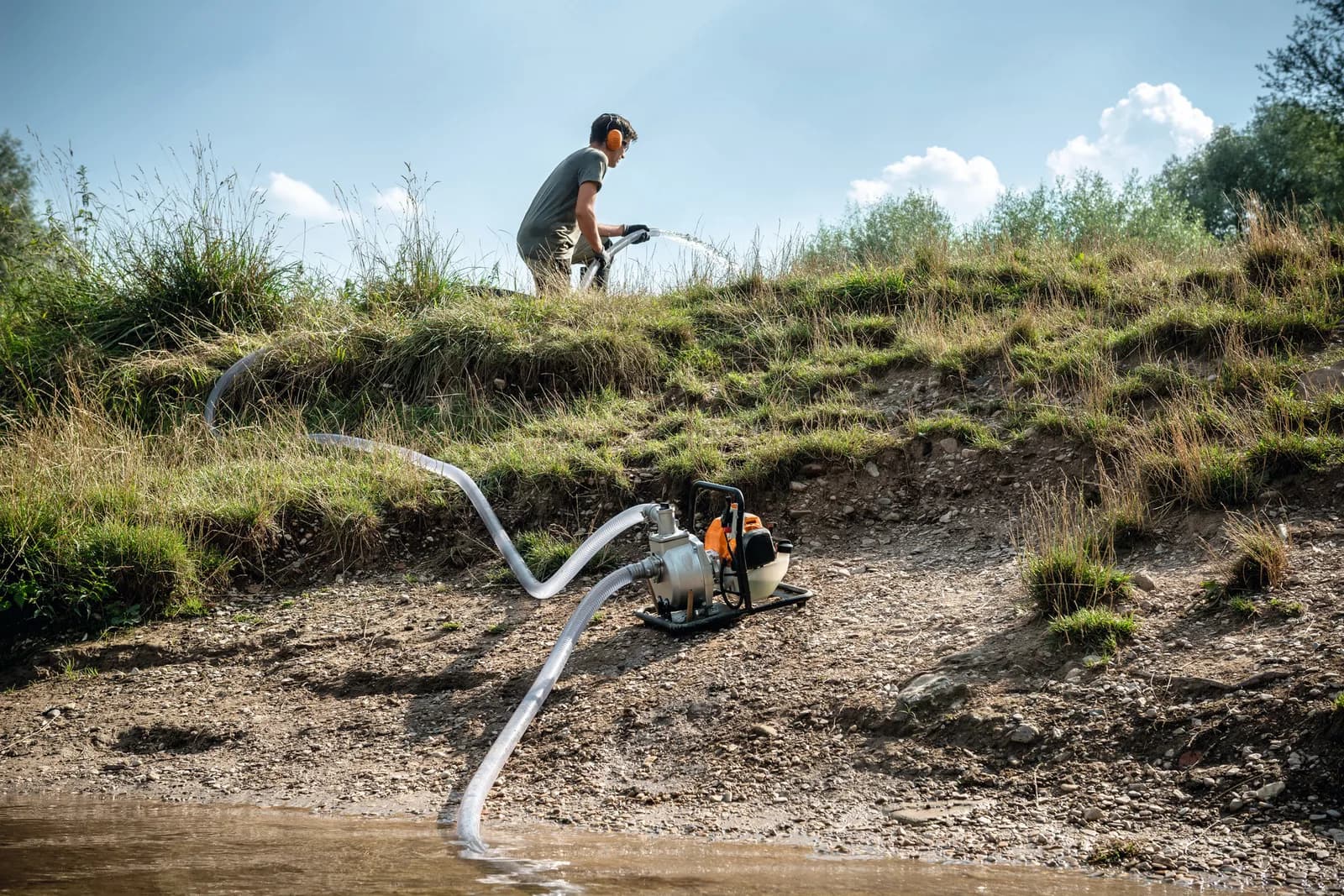 Motobomba STIHL trasladando agua en un terreno agrícola