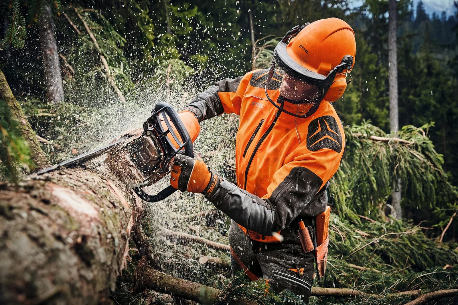 Operador protegido cortando madera con una motosierra STIHL
