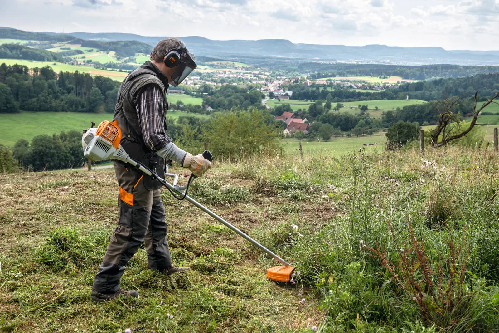 Operador trabajando en el campo con una desbrozadora STIHL